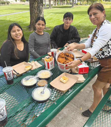 The students were treated to a picnic of fried chicken American-style with all the fixings by Tessa Gutierrez, right, and staff.  